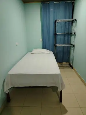 a bed in a room with a blue curtain at Cabinas El Jardin in Paquera