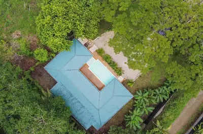 an overhead view of a blue house in a forest at Casa Manzanillo Surf in Manzanillo