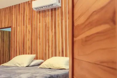 a bedroom with a bed and a wooden wall at Casa Manzanillo Surf in Manzanillo