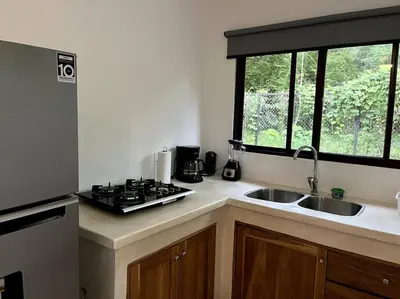 a kitchen with a stove and a sink and a window at Casa Manzanillo Surf in Manzanillo