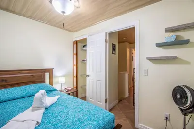 a bedroom with a blue bed and a fan at Casa Bella Vista Jaco #1 in Jacó