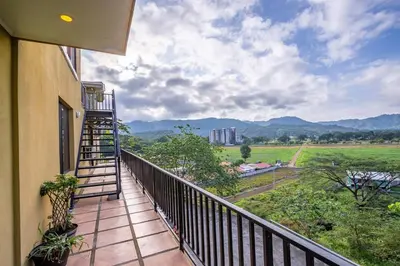 a balcony with a ladder and a view of the mountains at Casa Bella Vista Jaco #1 in Jacó