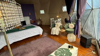 a bedroom with a tent with a bed and chairs at FéLIZA Rainforest Domes in Monteverde Costa Rica
