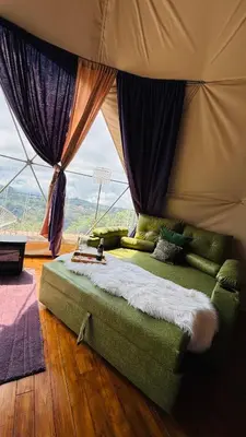 a bed in a room with a large window at FéLIZA Rainforest Domes in Monteverde Costa Rica