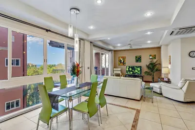 a living room with a table and green chairs at Casa feng shui in Tamarindo