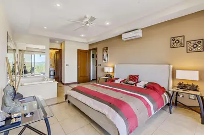 a bedroom with a large bed and a bath tub at Casa feng shui in Tamarindo