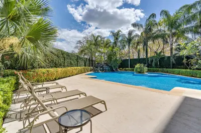 a row of lounge chairs next to a swimming pool at Casa feng shui in Tamarindo