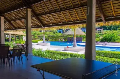 a ping pong table under a pavilion with a swimming pool at Ciudad del Mar 31 in Jacó