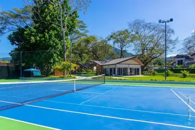 a tennis court in front of a house at Ciudad del Mar 31 in Jacó