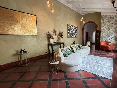 a living room with a white couch and a rug at The Victorian Hotel in San José