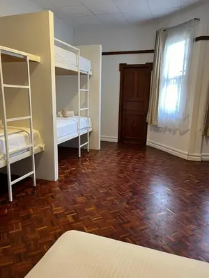 a room with two bunk beds and a wooden floor at The Victorian Hotel in San José