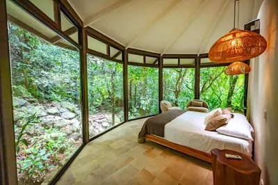 a bedroom with a bed in front of a window at The Nest Unique Jungle Retreat in Barú