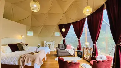 a bedroom with two beds and a tent at The SAFIRA Dome at FéLIZA Rainforest Domes in Monteverde Costa Rica