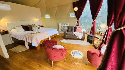 a bedroom with a bed and two chairs at The SAFIRA Dome at FéLIZA Rainforest Domes in Monteverde Costa Rica