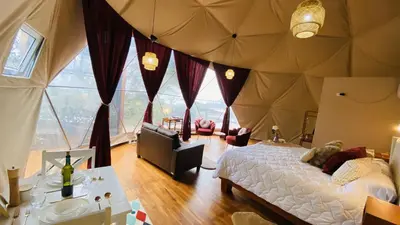 a bedroom with a large tent with large windows at The SAFIRA Dome at FéLIZA Rainforest Domes in Monteverde Costa Rica