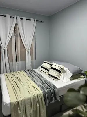 a white bedroom with a bed with two pillows at B&B Pacuare River Gateway Tica House in Linda Vista