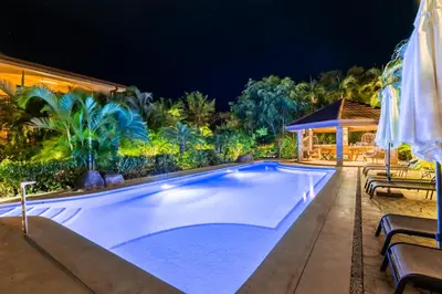 a swimming pool in a resort at night at Green Villas Tamarindo in Tamarindo