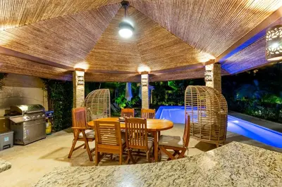 a dining room with a wooden table and chairs at Green Villas Tamarindo in Tamarindo