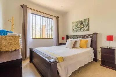 a bedroom with a large bed and a window at Green Villas Tamarindo in Tamarindo