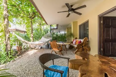 a living room with a hammock and a table and chairs at Green Villas Tamarindo in Tamarindo