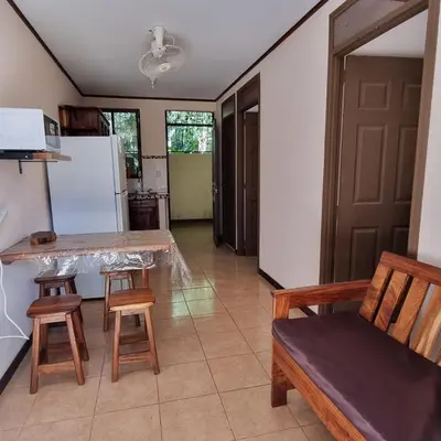 a kitchen with a table and chairs and a refrigerator at Cabinas en Playas del Coco in Sardinal