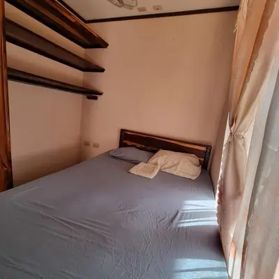 a small bedroom with a bed with a canopy at Cabinas en Playas del Coco in Sardinal