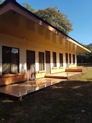 a small yellow building with doors and windows at Cabinas en Playas del Coco in Sardinal