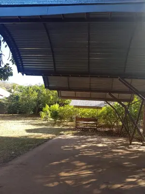 a park with a bench sitting under a roof at Cabinas en Playas del Coco in Sardinal