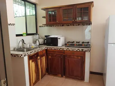 a kitchen with a sink and a stove top oven at Cabinas en Playas del Coco in Sardinal