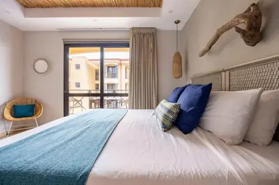 a bedroom with a large bed with blue and white pillows at Jaco Beachfront Oasis Newly renovated dream condo in Jacó