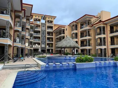 a swimming pool in front of a building at Jaco Beachfront Oasis Newly renovated dream condo in Jacó