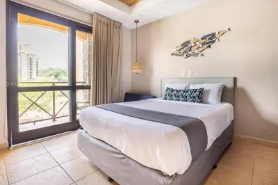 a bedroom with a large bed and a large window at Jaco Beachfront Oasis Newly renovated dream condo in Jacó