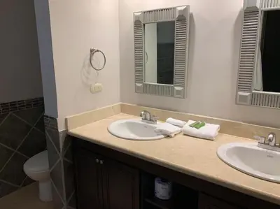 a bathroom with two sinks and a toilet at Jaco Beachfront Oasis Newly renovated dream condo in Jacó