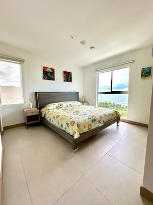 a bedroom with a bed and two windows at Grettabril JACO BEACH APARTMENT in Jacó