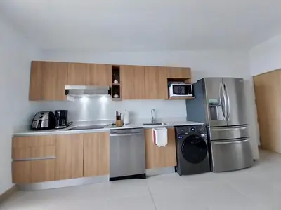a kitchen with a stainless steel refrigerator and a dishwasher at Grettabril JACO BEACH APARTMENT in Jacó