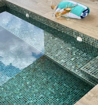 a pool with two glasses of wine and a table with wine glasses at Antemar Guest, Beach bungalow near Conchal in Brasilito