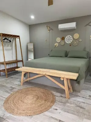 a bedroom with a bed and a wooden table at Antemar Guest, Beach bungalow near Conchal in Brasilito