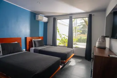 a hotel room with two beds and a window at Casa Plata - 10 bed, 5 bdrm - One Block from Clubs in Jacó
