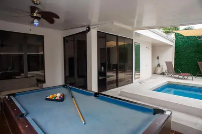 a pool table in a room with a swimming pool at Casa Plata - 10 bed, 5 bdrm - One Block from Clubs in Jacó