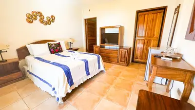 a bedroom with a bed and a television in it at Mango Moon Villa in Manuel Antonio