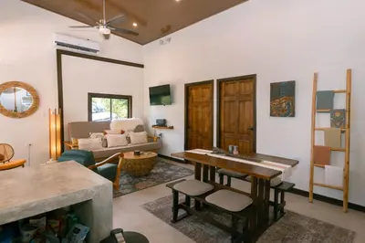 a living room with a table and a couch at Jungle Glory Home Arriba in Manuel Antonio