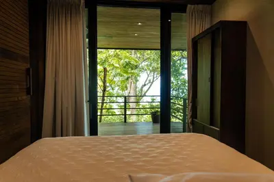 a bedroom with a bed and a large window at Casa VISTA PARAISO - Vista al mar - Selva - WIFI - Deck Yoga - Sunset in Santa Teresa Beach