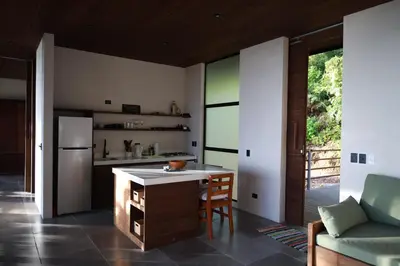 a kitchen with a island in the middle of a room at Casa VISTA PARAISO - Vista al mar - Selva - WIFI - Deck Yoga - Sunset in Santa Teresa Beach