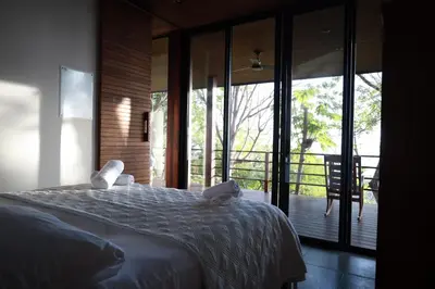 a bedroom with a large bed and a balcony at Casa VISTA PARAISO - Vista al mar - Selva - WIFI - Deck Yoga - Sunset in Santa Teresa Beach