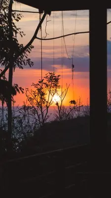 a sunset seen through the window of a house at Casa VISTA PARAISO - Vista al mar - Selva - WIFI - Deck Yoga - Sunset in Santa Teresa Beach