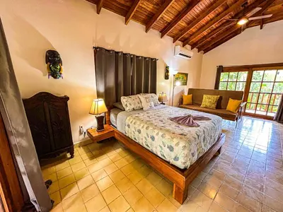 a bedroom with a bed and a couch at 3 minutes walk from the best surf beach in area in Dominical