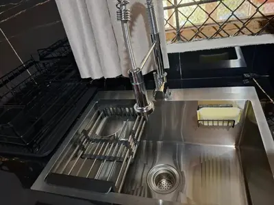 a stainless steel kitchen sink with a faucet at Coco Beach House in Coco
