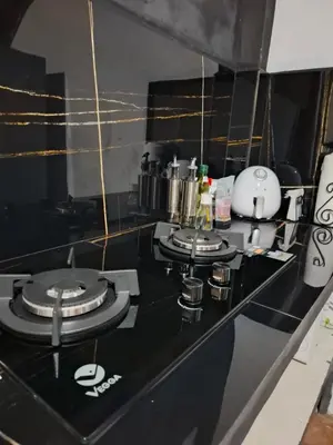 a kitchen with a black counter top with a stove at Coco Beach House in Coco