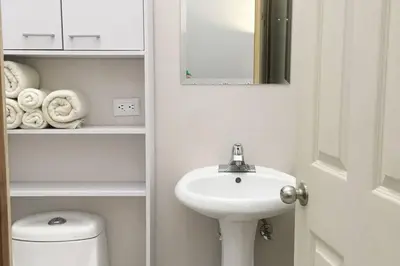 a bathroom with a sink and a toilet and a mirror at Bello espacio en zona rodeada de naturaleza Apt 2 in Curridabat