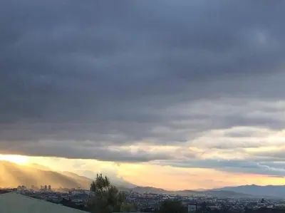 a cloudy sky with a city in the background at Bello espacio en zona rodeada de naturaleza Apt 2 in Curridabat